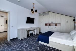 a bedroom with a bed and a desk and a tv at Eros Beach Resort in Mamaia Sat/Năvodari