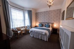 um quarto de hotel com uma cama e uma cadeira em Appley Lodge em Shanklin