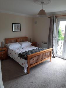 1 dormitorio con 1 cama y puerta corredera de cristal en Mount Wolseley Holiday Home - Privately Owned, en Tullow