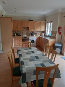 a kitchen with a table and chairs and a kitchen with a table and a table at Mount Wolseley Holiday Home - Privately Owned in Tullow +5 photos
