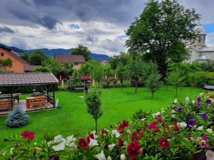 een groene tuin met bloemen en een gebouw bij casa melinda in Vişeu de Sus