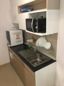 a kitchen with a sink and a microwave at Supalai Rama9 Monthly in Bangkok
