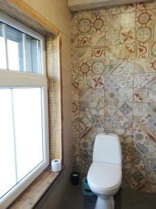 een badkamer met een toilet en een raam bij Brīvupes in Balvi