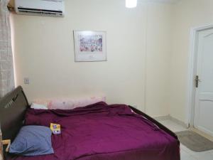 a bed with a purple blanket in a room at شاليه للايجار بقرية فيستا مارينا بالعلمين الجديدة in El Alamein