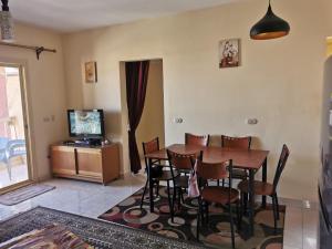 a dining room with a table and chairs and a television at شاليه للايجار بقرية فيستا مارينا بالعلمين الجديدة in El Alamein