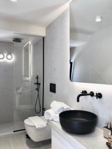 a bathroom with a black sink and a toilet at Candele Suites in Fira