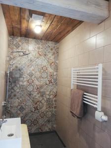 een badkamer met een wastafel en een betegelde muur bij Brīvupes in Balvi