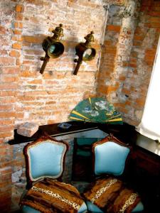 a brick wall with a table and two chairs at Torre Ducale Dimora Storica in Genova