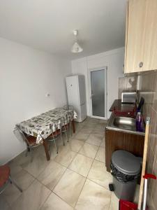 uma cozinha com um lavatório e uma mesa em Apartament Sofia em Costinesti