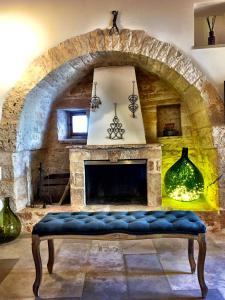 a living room with a stone fireplace and a blue bench at Trulli e Puglia Resort in Alberobello