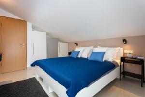 1 dormitorio con 1 cama grande con sábanas azules en Apartments Iris, en Marina