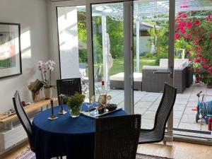 einen Esstisch mit einem blauen Tischtuch und Stühlen in der Unterkunft Villa Starnberger See in Pöcking