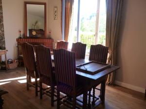 comedor con mesa de madera y sillas en Chambres d'Hôtes L'Hirondelle du Lac, en Peyrat-le-Château