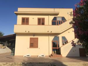 una casa bianca con due sedie bianche davanti di 3 bedrooms apartement at Menfi 800 m away from the beach with sea view enclosed garden and wifi a Menfi