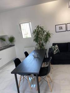 uma sala de estar com uma mesa preta e cadeiras em OIKOI II em Koropíon