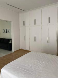 1 dormitorio blanco con armarios blancos y 1 cama en OIKOI II, en Koropíon