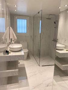 - Baño blanco con 2 lavabos y ducha en OIKOI II, en Koropíon