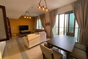 a living room with a table and a couch and a television at Quiet and cozy 2 BR apartment with stunning views in Dubai