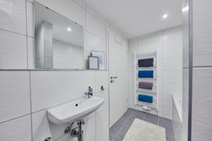 uma casa de banho branca com um lavatório e um espelho em Wohnung 11 - nur 10 Minuten zu Fuß in den Europa-Park em Rust