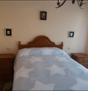 una camera da letto con un letto e un piumone bianco di piso María C a Santiago de Compostela