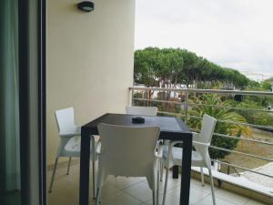 a dining room table with white chairs and a balcony at Apartamento T2 Eucalipto 2A in Olhos de Água