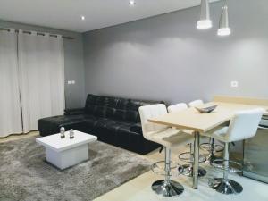 a living room with a black couch and a table at Apartamento T2 Eucalipto 2A in Olhos de Água