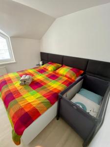 Luxury apartman Bojnice في بوينيتسا: غرفة نوم مع سرير وبطانية ملونة