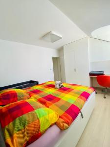 a dog laying on a colorful bed in a room at Luxury apartman Bojnice in Bojnice