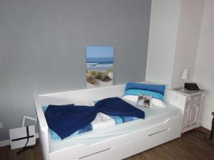 a bedroom with a white bed with blue pillows at Miramar in Dahme