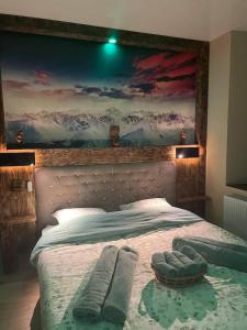 a bedroom with a bed with a painting on the wall at Auberge du Raddon in Raddon-et-Chapendu