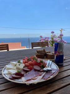 a plate of food with meat and cheese and a can of soda at Apartments Villa Sveti Nikola in Budva