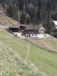 un grupo de edificios en una colina con un campo en Hauserbauer - AusZEIT in Rauris, en Rauris