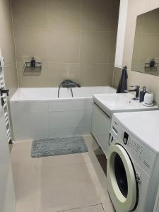 a bathroom with a washing machine next to a sink at Luxury apartman Bojnice in Bojnice