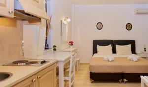 a room with a bed and a kitchen with a sink at Irini Stalis by Estia in Stalida