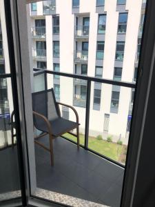 a chair on a balcony with a view of a building at Apartamenty Platinex 3 in Krakow