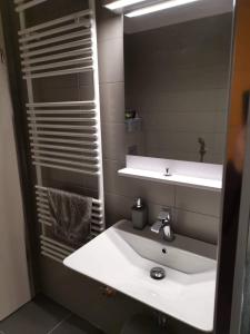 a bathroom with a white sink and a mirror at MANDARA WELLNES APARTMANOK in Siófok