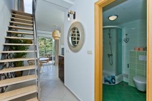 a bathroom with a staircase and green tile floors at Luxurious Apartments Maslina with Beach in Milna