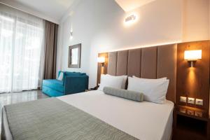 a bedroom with a large bed and a blue chair at 4- you Family in Metamorfosi