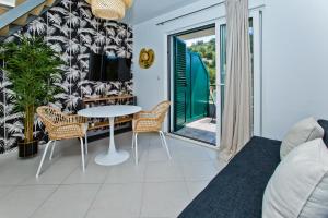 a living room with a table and chairs at Luxurious Apartments Maslina with Beach in Milna