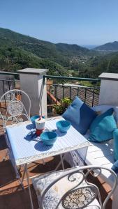 - une table blanche avec des bols sur le balcon dans l'établissement La casetta dei pesciolini, à Sestri Levante