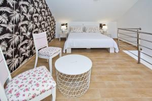 a bedroom with a bed and two chairs and a table at Luxurious Apartments Maslina with Beach in Milna