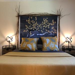 Le Nid des Corbières في Bizanet: غرفة نوم مع سرير مع مصباحين على جانبي