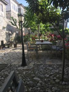 a stone patio with a table and chairs and a street light at Hotel Klea in Berat