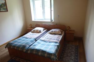 Dormitorio pequeño con cama y ventana en Leśny Dworek, 