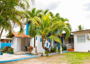 une maison avec des palmiers devant elle dans l'établissement HOSPEDAJE VILLAMAR, à Nueva Gorgona