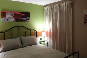 Un dormitorio con una cama y una pared verde. en 6 Ad un passo dal centro, en Aosta