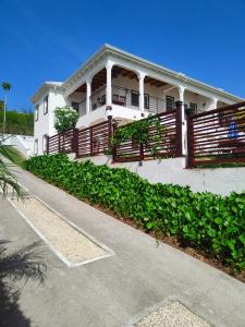 a large white house with a porch and a driveway at Holiday Home Belvedere in Dickenson Bay