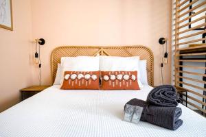 een slaapkamer met een wit bed met 2 kussens bij Studio de charme - calme, discret & cosy - 3' RER in Évry-les-Châteaux