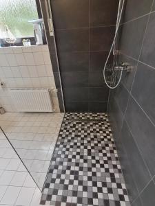 een badkamer met een zwart-wit geruite vloer bij Ferienwohnung DORO in Kelberg