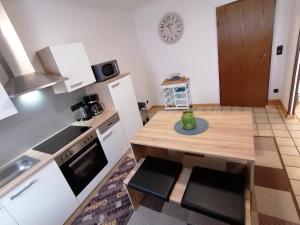 een kleine keuken met een tafel en een klok aan de muur bij Ferienwohnung DORO in Kelberg
